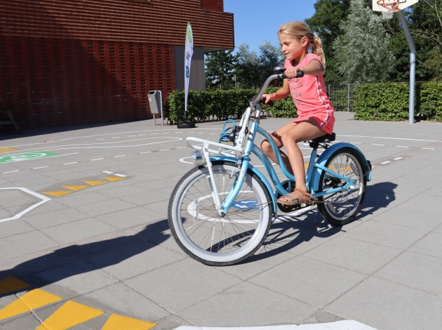 Meisje op fiets op verkeersplein