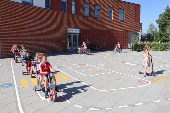 kinderen fietsen op verkeersplein